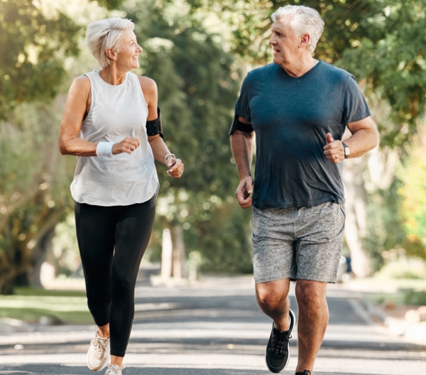 older man and woman jogging outside